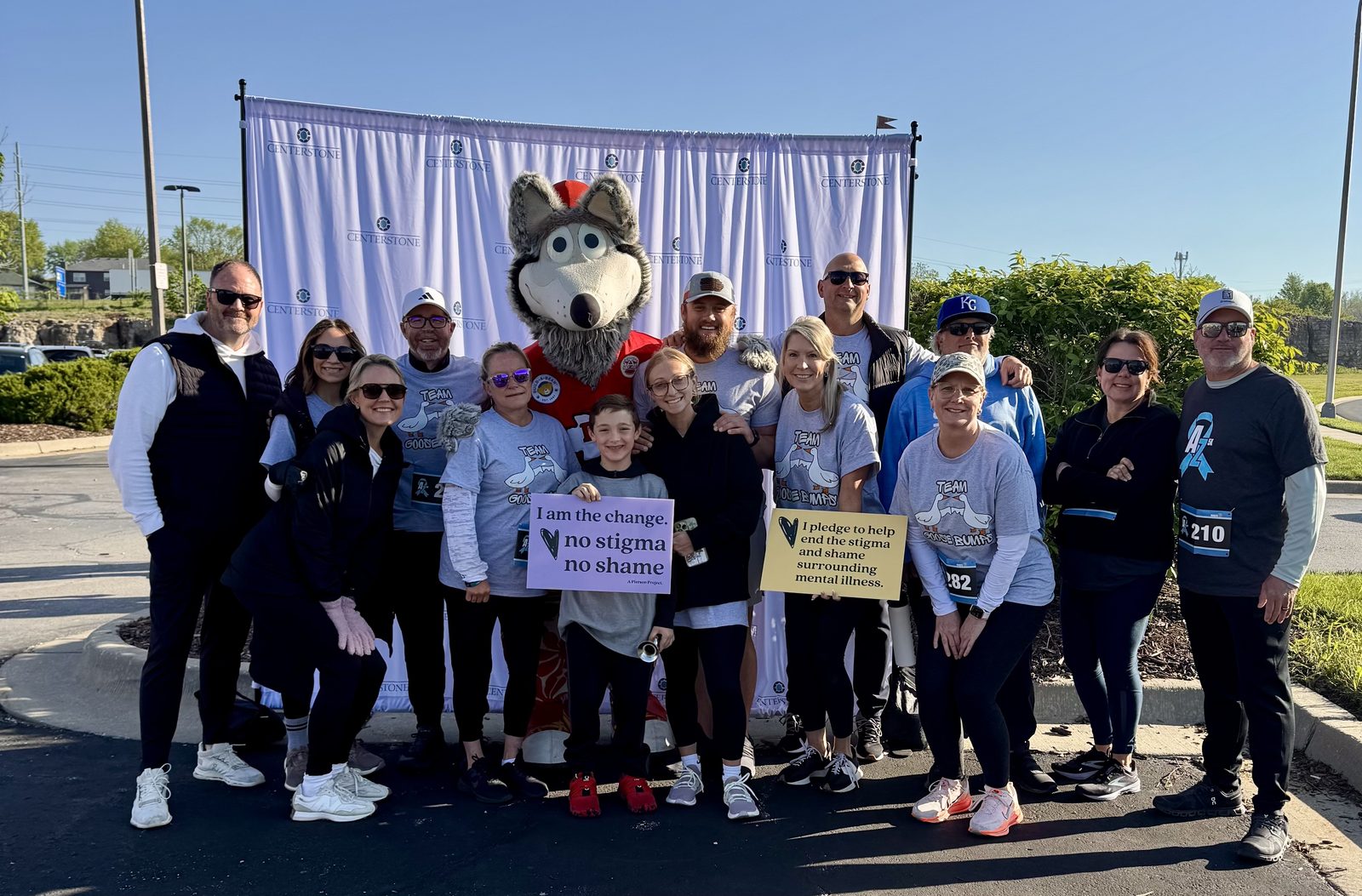 Group of walk participants with mascot holding no stigma, no shame signs